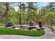 Landscaped backyard with a stone patio, water feature, and mature trees at 646 Ruby Trust Dr, Castle Rock, CO 80108