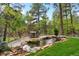 Beautiful backyard with a rock-lined pond and waterfall feature near a dining table at 646 Ruby Trust Dr, Castle Rock, CO 80108