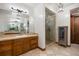 Bathroom featuring dual vanity, decorative mirrors, tile floors, glass shower, and linen closet at 646 Ruby Trust Dr, Castle Rock, CO 80108