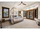 Bright primary bedroom featuring a four-poster bed, many windows, and neutral decor at 646 Ruby Trust Dr, Castle Rock, CO 80108