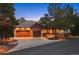 Charming home featuring a stone exterior, wood accents, well-lit driveway, and mature trees at 646 Ruby Trust Dr, Castle Rock, CO 80108