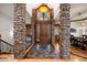 Stunning foyer featuring stone columns, a wood door, and hardwood floors at 646 Ruby Trust Dr, Castle Rock, CO 80108