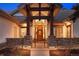 Inviting front entrance with stone columns, a wood door, and a well-lit walkway at 646 Ruby Trust Dr, Castle Rock, CO 80108
