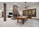 Recreation room featuring fireplace, billiards table, stone pillars, and access to outdoor balcony at 646 Ruby Trust Dr, Castle Rock, CO 80108