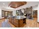 Open concept with a kitchen island with hardwood floors and a stone fireplace at 646 Ruby Trust Dr, Castle Rock, CO 80108