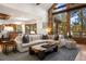 Bright living room with high windows, stone accents, and forest views at 646 Ruby Trust Dr, Castle Rock, CO 80108