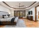 Bright main bedroom with hardwood floors, dresser with TV, and access to a balcony via french doors at 646 Ruby Trust Dr, Castle Rock, CO 80108