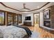 Spacious main bedroom with a stone fireplace, hardwood floors, and french doors to the outside at 646 Ruby Trust Dr, Castle Rock, CO 80108