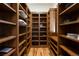 Spacious pantry with custom wooden shelving and hardwood floor for organized storage at 646 Ruby Trust Dr, Castle Rock, CO 80108