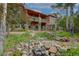 Multi-level backyard with stone patio, pond, lush landscaping, and a spacious home at 2941 Castle Butte Drive Dr, Castle Rock, CO 80109