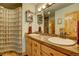 A bathroom with a double sink vanity, a shower with glass blocks, and a mirror at 2941 Castle Butte Drive Dr, Castle Rock, CO 80109