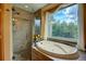 Relaxing bathroom with a soaking tub, glass shower and a scenic outdoor view at 2941 Castle Butte Drive Dr, Castle Rock, CO 80109