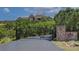 Gated driveway entrance with stone pillars ensuring privacy to the residence, surrounded by mature trees at 2941 Castle Butte Drive Dr, Castle Rock, CO 80109