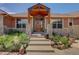 Inviting front entrance with a custom wood door, stone accents, and professionally landscaped front yard at 2941 Castle Butte Drive Dr, Castle Rock, CO 80109