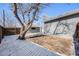 Backyard featuring a large tree providing shade and privacy, with a gray brick outbuilding and wood fence at 5895 S Huron St, Littleton, CO 80120