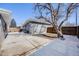 Backyard featuring a large tree providing shade and privacy, with a gray brick outbuilding and concrete patio at 5895 S Huron St, Littleton, CO 80120