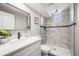 Modern bathroom featuring a tiled shower with a black accent stripe and glass shelves at 5895 S Huron St, Littleton, CO 80120