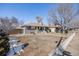 Lovely single-story home with a well-maintained lawn, partially snow-covered, and a quaint fence outlining the property at 5895 S Huron St, Littleton, CO 80120