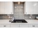 Kitchen detail showcasing sleek countertops, modern backsplash, and a smooth cooktop at 5895 S Huron St, Littleton, CO 80120