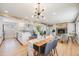 Bright, open-concept living room featuring wood floors, modern lighting, fireplace, and seamless flow to the dining area at 5895 S Huron St, Littleton, CO 80120