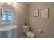 Stylish half bath with a pedestal sink, neutral walls, and decorative wall art at 2908 Open Sky Way, Castle Rock, CO 80109