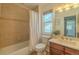 Cozy bathroom featuring a shower-tub, a window and cherry wood vanity at 2908 Open Sky Way, Castle Rock, CO 80109