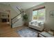 Bright living room with hardwood floors, a staircase, a fireplace, and natural light from a large window at 2908 Open Sky Way, Castle Rock, CO 80109