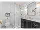 Elegant bathroom featuring a glass-enclosed shower, stylish vanity with gold fixtures, and modern lighting at 2068 Jasmine St, Denver, CO 80207