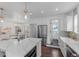 Modern kitchen boasts white cabinets, quartz countertops, and a farmhouse sink at 2068 Jasmine St, Denver, CO 80207