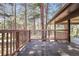 Back deck with a wooden railing overlooking a treed backyard at 8782 S Ault Ln, Morrison, CO 80465