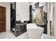 Modern bathroom with a standalone tub, marble accents, and a large window with a scenic view at 8782 S Ault Ln, Morrison, CO 80465