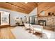 Open-concept living room with stone fireplace, vaulted wood ceilings, and seamless indoor/outdoor flow at 8782 S Ault Ln, Morrison, CO 80465
