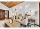 Bright living room with arched room openings, wood ceiling and comfortable seating arrangement at 8782 S Ault Ln, Morrison, CO 80465