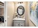 Elegant half bathroom featuring a vanity with marble countertop and decorative mirror at 17053 E Jamison Ave, Centennial, CO 80016