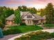 Charming home with brick and stone exterior, lush green lawn, and mature trees at sunset at 17053 E Jamison Ave, Centennial, CO 80016