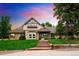 Charming home featuring stone and brick exterior, landscaped front yard, and a welcoming entrance with brick steps at 17053 E Jamison Ave, Centennial, CO 80016
