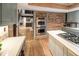 Gourmet kitchen with built-in stainless appliances and brick accents at 17053 E Jamison Ave, Centennial, CO 80016