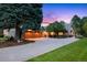 Charming home featuring a two-car garage, stone accents, a well-manicured lawn, and mature trees at 18 Club Ln, Littleton, CO 80123