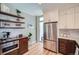 Bright kitchen with stainless steel refrigerator, wooden cabinets, floating shelves, and hardwood floors at 636 N Logan St, Denver, CO 80203