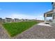 Spacious backyard features a lush green lawn, decorative gravel, wooden fencing, and view of houses in the distance at 1172 Elbridge Cir, Elizabeth, CO 80107