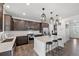 Modern kitchen with island seating, stainless steel appliances, and dark wood cabinets at 1172 Elbridge Cir, Elizabeth, CO 80107