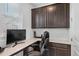 Built-in office nook featuring dark wood cabinetry, white countertop, and gaming monitor at 1172 Elbridge Cir, Elizabeth, CO 80107
