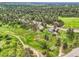 Aerial view of a home surrounded by lush greenery, trails, and other homes in a beautiful neighborhood at 5583 Thunder Hill Rd, Parker, CO 80134