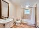 Well-lit bathroom featuring a pedestal sink and shower-tub combination with a light tile surround at 5583 Thunder Hill Rd, Parker, CO 80134