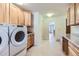 Bright laundry room with wooden cabinets, tile floors, and modern appliances at 5583 Thunder Hill Rd, Parker, CO 80134