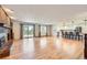Open-concept living space with a brick fireplace, hardwood floors, and access to the kitchen at 5583 Thunder Hill Rd, Parker, CO 80134
