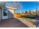Backyard featuring a grassy area, wooden deck, and wooden fence at 5500 Holland Dr, Arvada, CO 80002