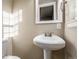 Bathroom features a modern pedestal sink, mirror, and neutral wall color at 5500 Holland Dr, Arvada, CO 80002