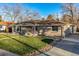 Landscaped front yard features a well-manicured lawn, rock details, and an inviting facade at 5500 Holland Dr, Arvada, CO 80002