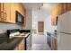 Kitchen featuring wood cabinets, black granite countertops, and an adjoining living space at 850 20Th St # 201, Boulder, CO 80302